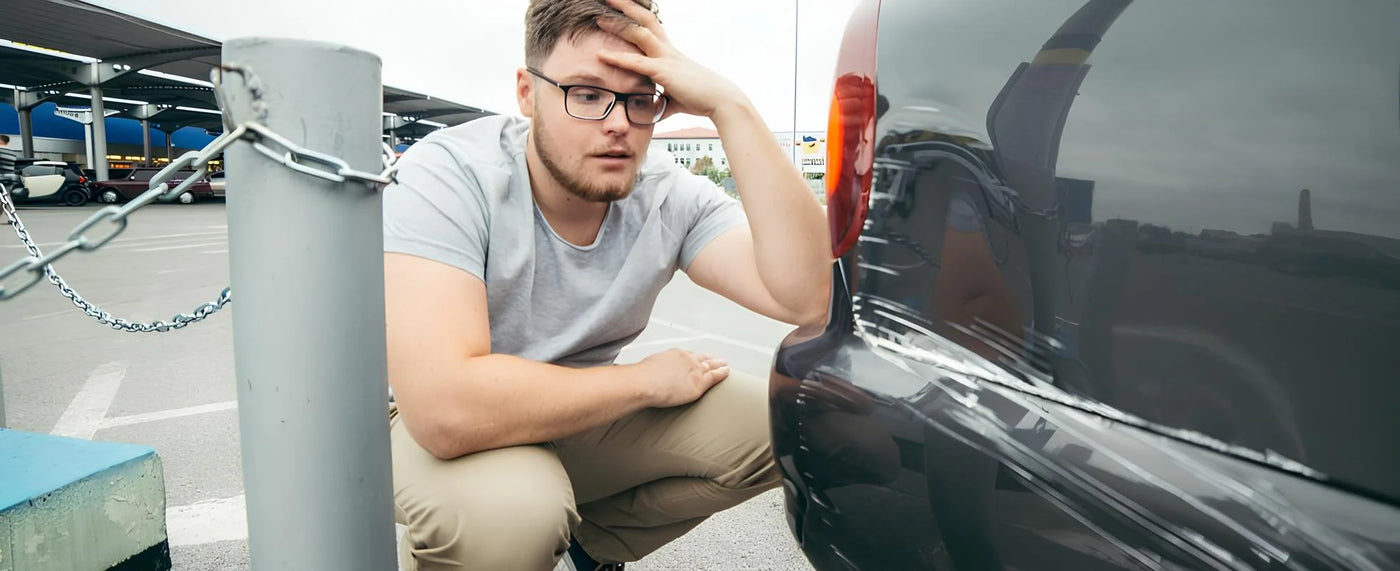 Driver inspecting a scratched car